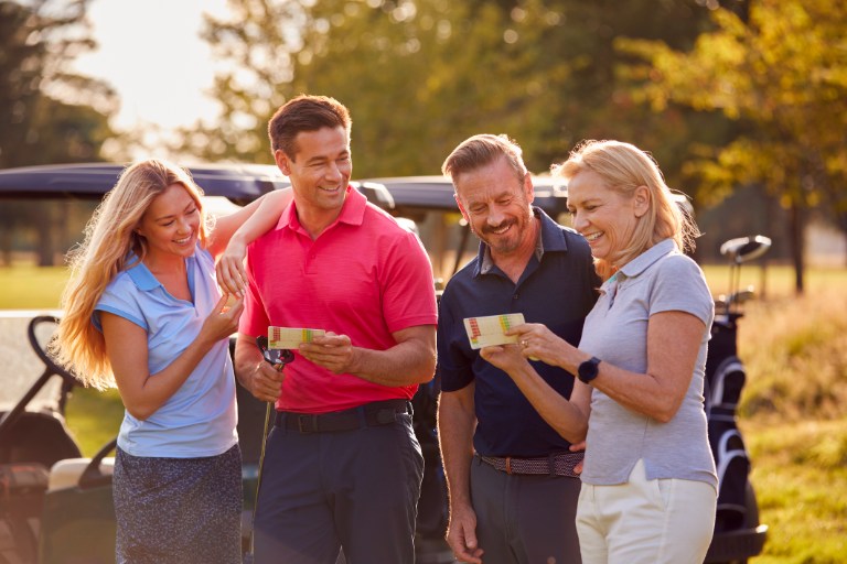 Couples Standing By Golf Buggy