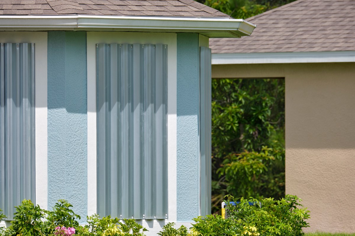 Steel sheets mounted as storm shutters for hurricane protection of house windows